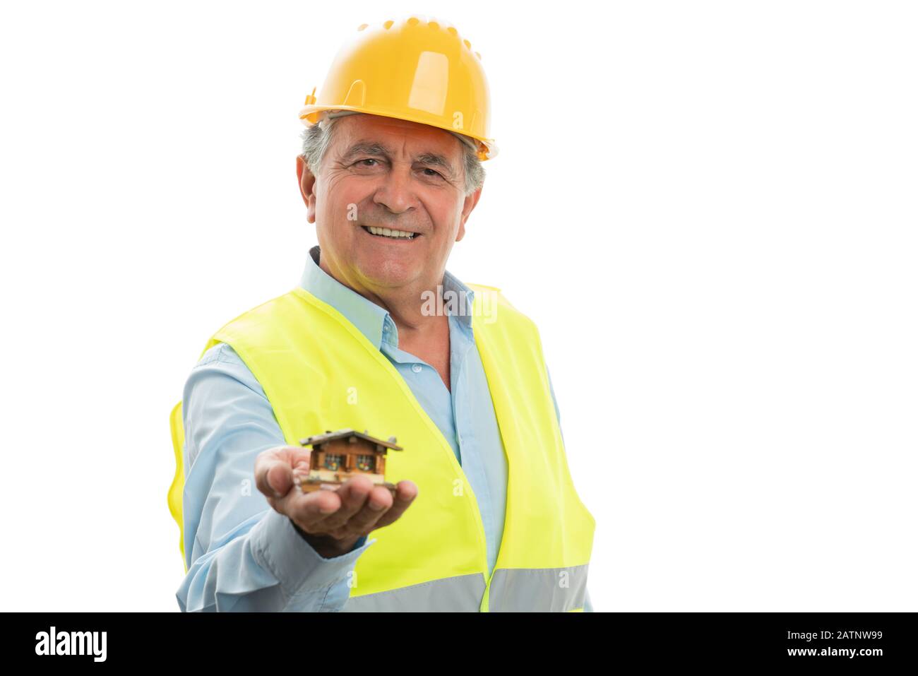 Alter Ingenieur mit freundlichem Lächeln präsentiert kleines Holzhaus als Gebäudekonzept isoliert auf weißem Hintergrund Stockfoto