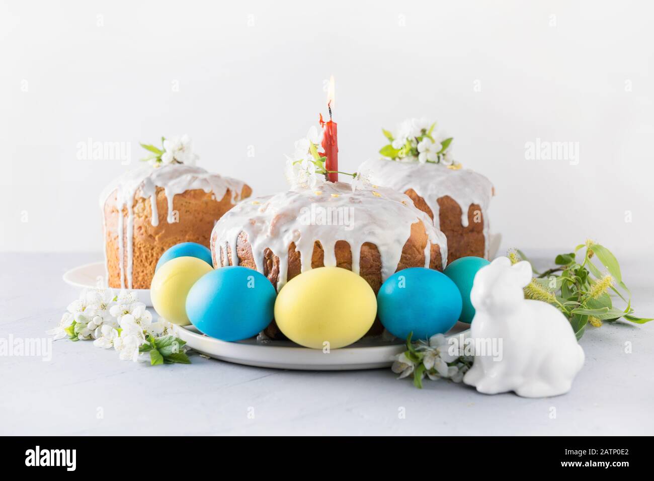 Kulich und bunte blaue und gelbe Eier, Frühlingsblumen auf hellem Hintergrund. Nahaufnahme. Traditionelles Frühstück im oster-christenthum. Stockfoto