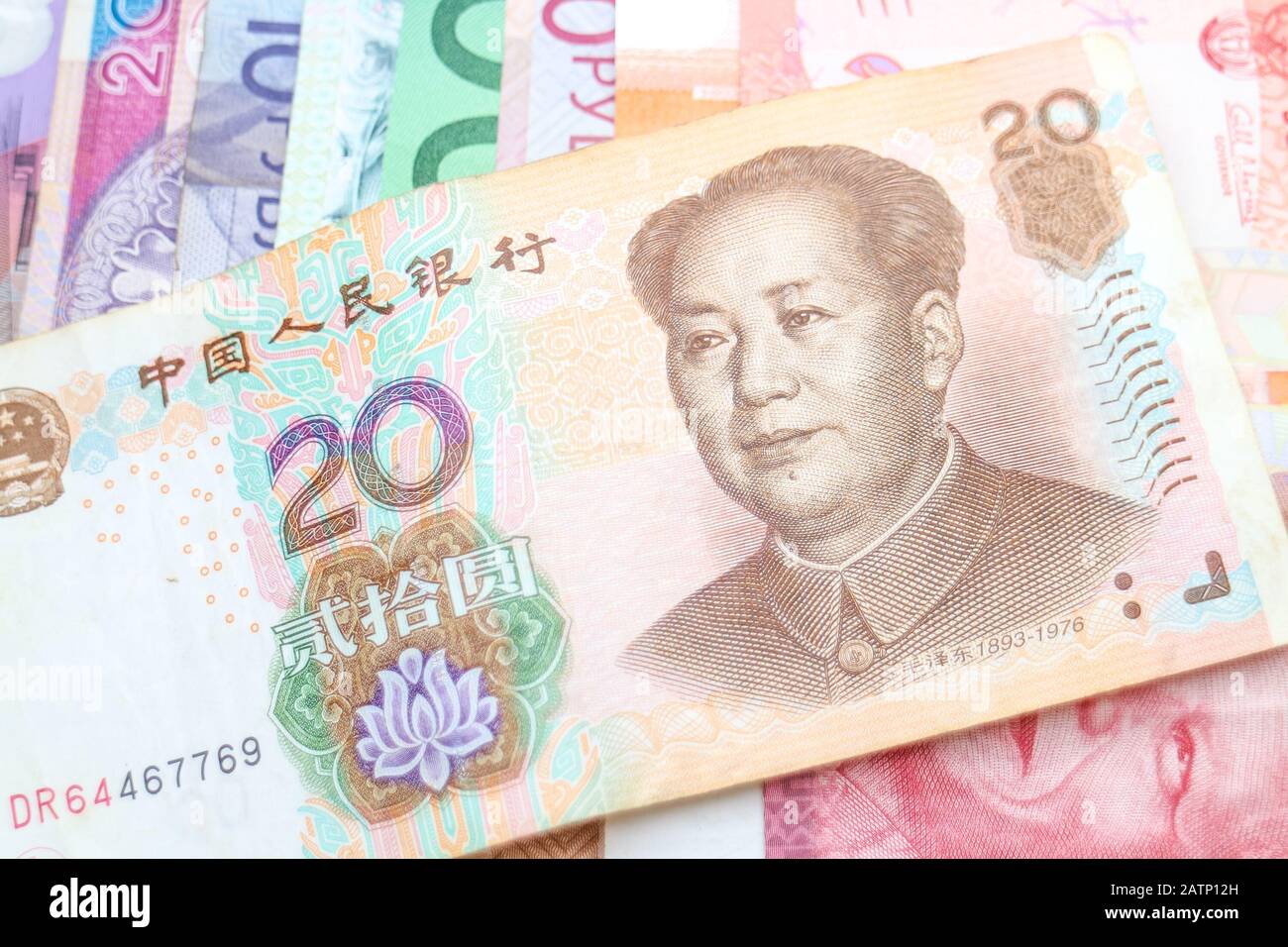 Eine chinesische Yuan-Banknote, die diagonal auf einem Regenbogen von Banknoten verschiedener Weltwährungen angeordnet ist, darunter Euro, Schekel, Rand und Polnisch Złoty. Stockfoto