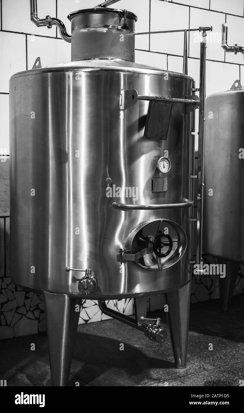 Stahlfass mit Manometer steht in der Weinfabrik. Schwarzweißfoto Stockfoto