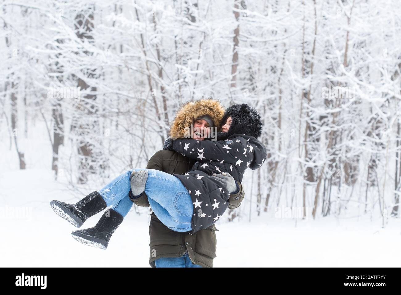 Junge Paare, die in einem verschneiten Park spazieren gehen. Wintersaison Stockfoto