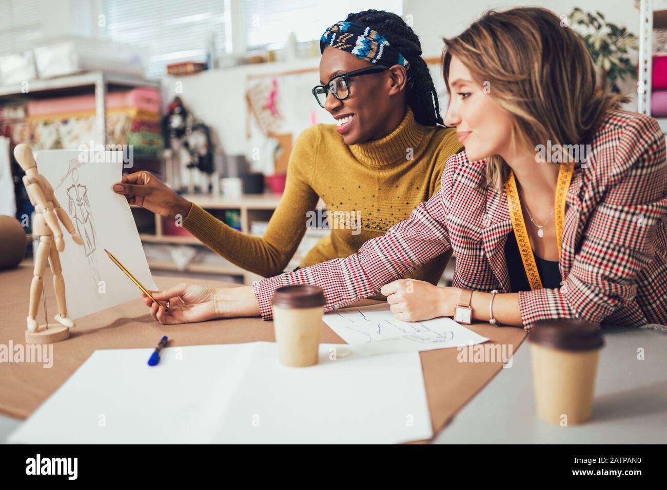 Zwei junge Unternehmerinnen oder Modedesigner, die im Atelier arbeiten Stockfoto
