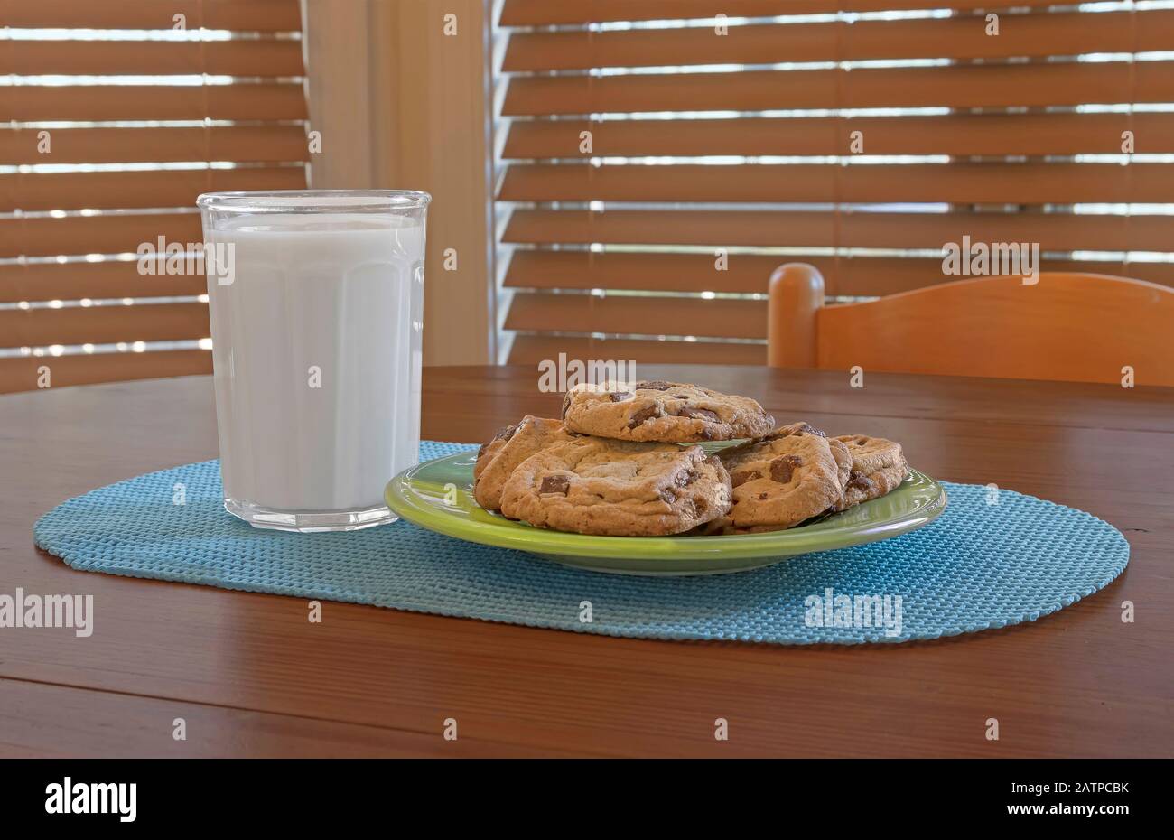 Glas Milch mit Schokoladen-Chip-Plätzchen auf Küchentisch Stockfoto