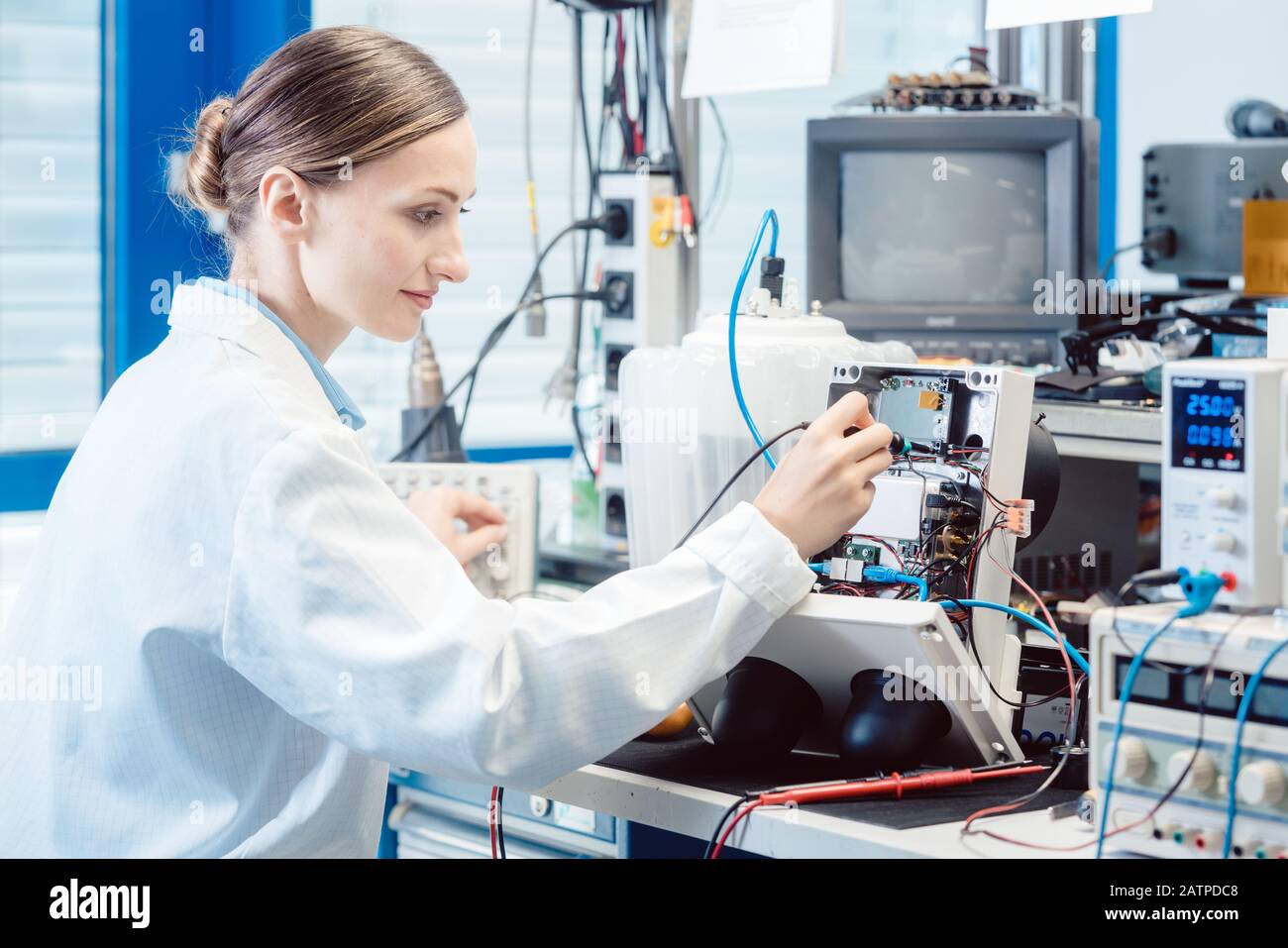 Ingenieurin Frau misst elektronisches Produkt auf Prüfstand Stockfoto