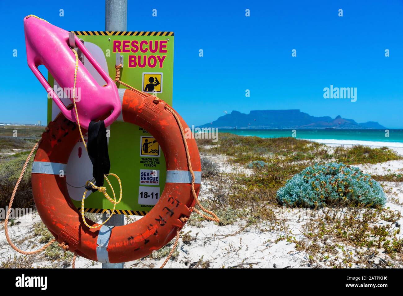 Rettungsboje oder Rettungsboje am weißen Sandstrand von Bloubergstrand mit Table Bay und Table Mountain im Hintergrund - Kapstadt, Südafrika Stockfoto