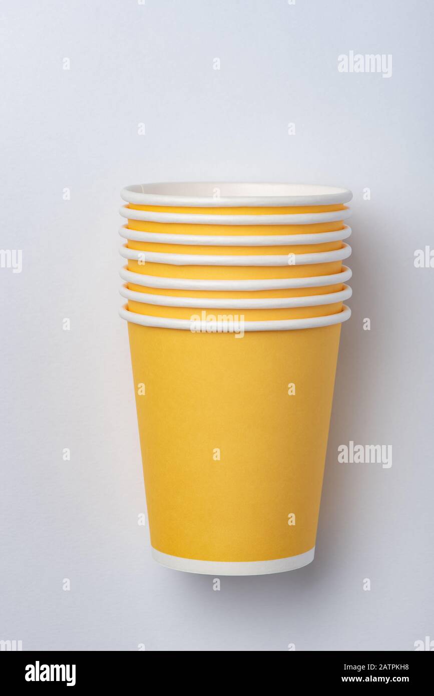 Gelbe umweltfreundliche Papierbecher für eine Party auf weißem Hintergrund Stockfoto