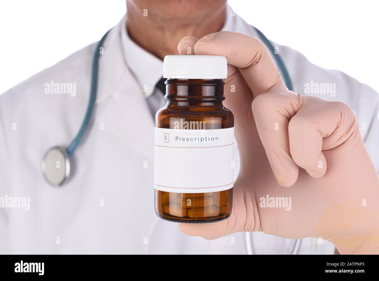 Ein medizinischer Fachmann, der eine Perskriptionsflasche in einer Hand bis zur Kamera hält. Die Person ist nicht im Fokus und nicht erkennbar. Stockfoto