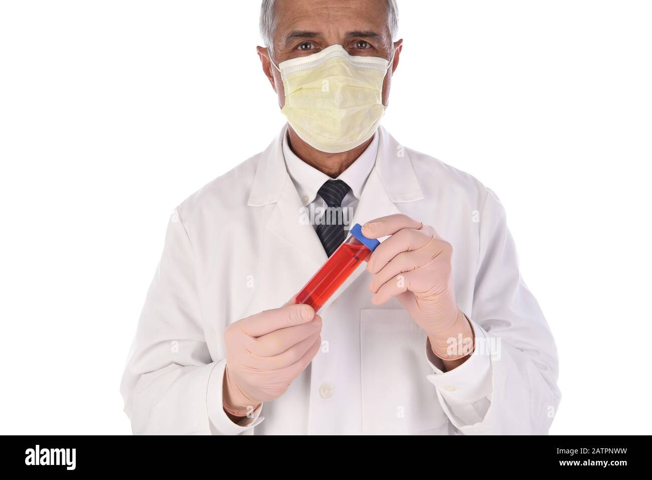 Labortechniker, der eine Durchstechflasche mit roter Flüssigkeit vor seinem Körper hält. Der Mann trägt eine Schutzmaske, um eine Infektion zu verhindern. Stockfoto