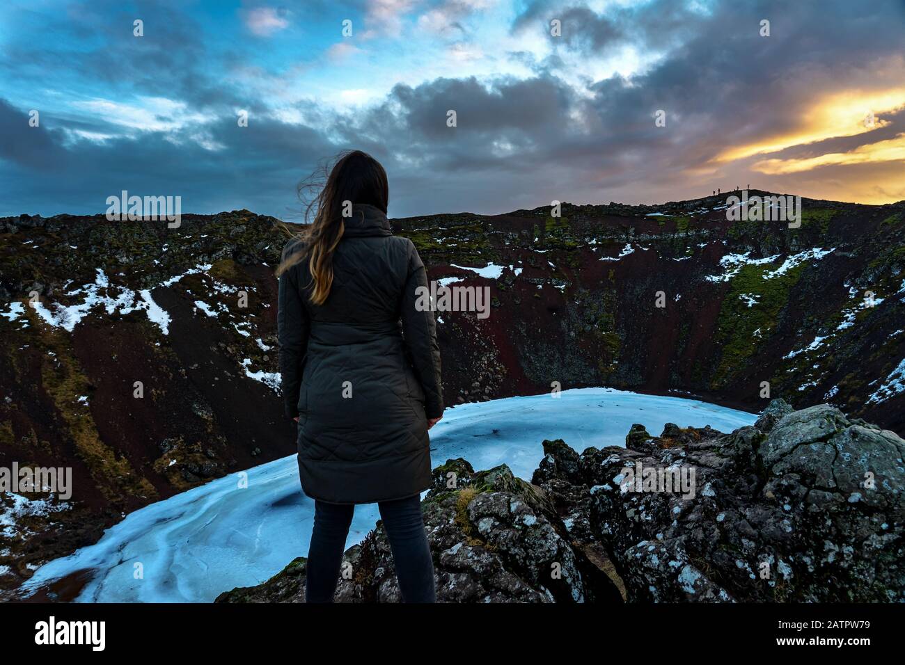 Frau, die auf der Klippe des Keritkraters in Island steht, wundert sich über Abenteuer auf Island Stockfoto