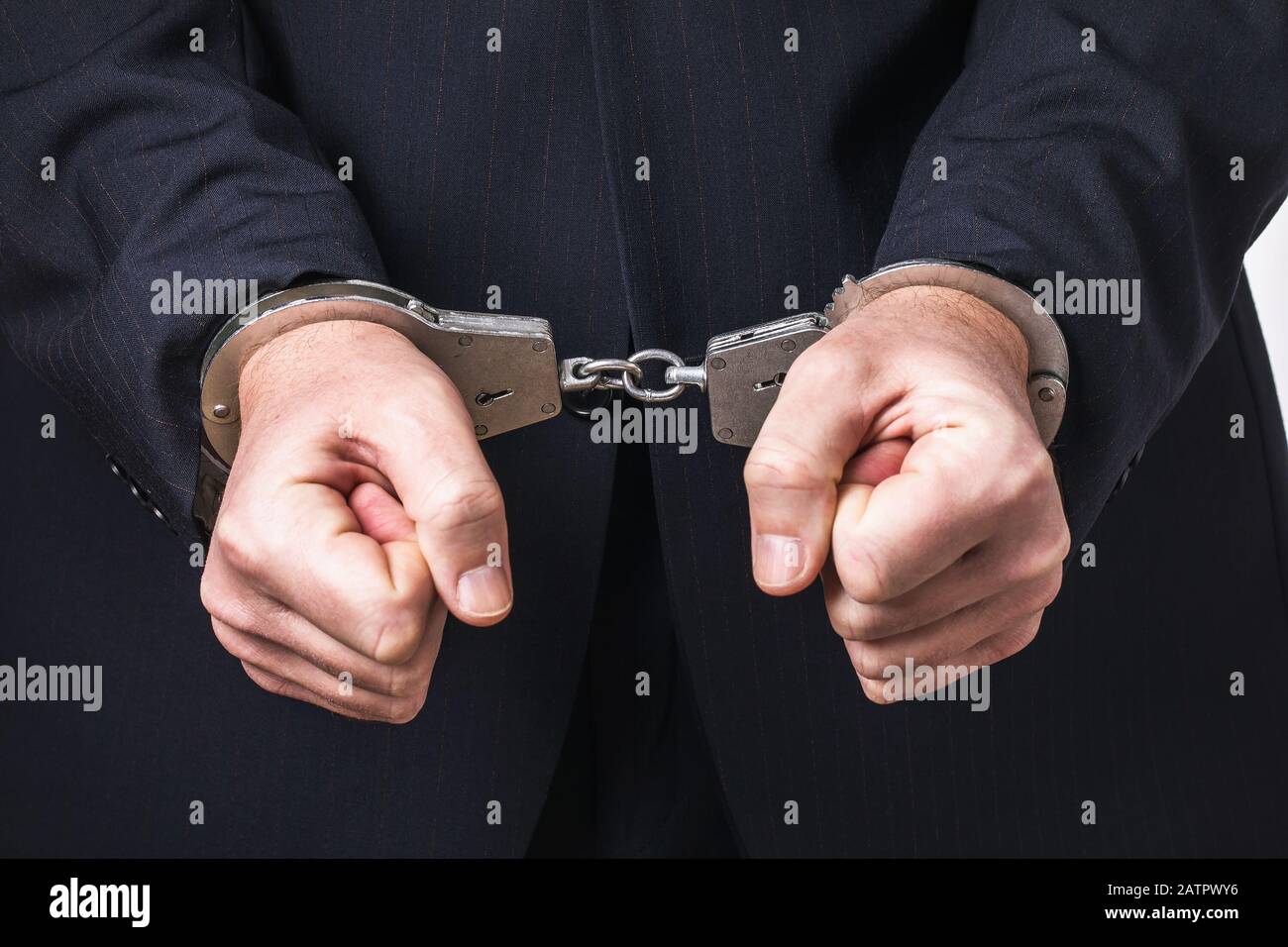 Ein Mann in Anzug und Handschellen, Nahaufnahme. Haftkonzept Stockfoto