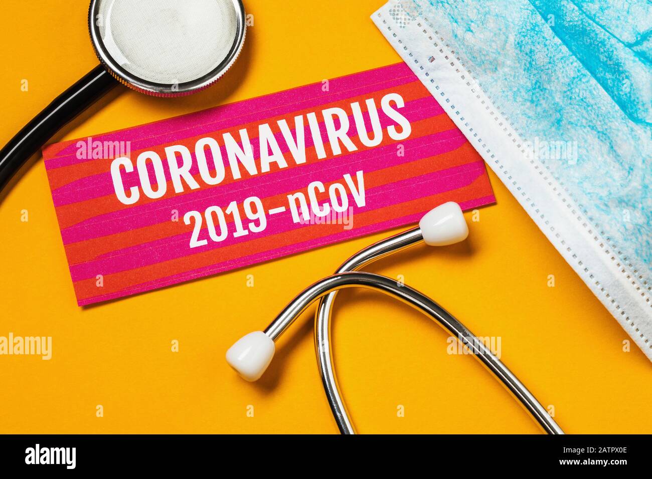 Stethoskop, Maske und ein Blatt Papier mit der Aufschrift auf gelbem Hintergrund. Coronavirus 2019-nCoV-Konzept Stockfoto