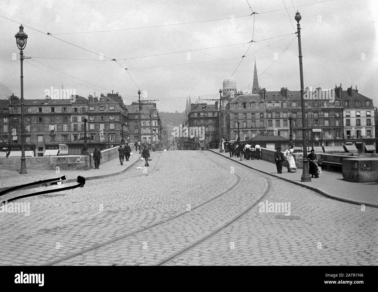 AJAXNETPHOTO.1905 (CA.).ROUEN, FRANKREICH. - BRÜCKE PONT PIERRE CORNEILLE - BLICK ÜBER DIE GEPFLASTERTE BRÜCKE IN RICHTUNG STADT VON DER WESTSEITE DER SEINE. TRAMLINIEN IN KOPFSTEINPFLASTER UND OBERLEITUNGEN. FOTO:AJAX VINTAGE PICTURE LIBRARY REF:ROUEN 1905 7 Stockfoto