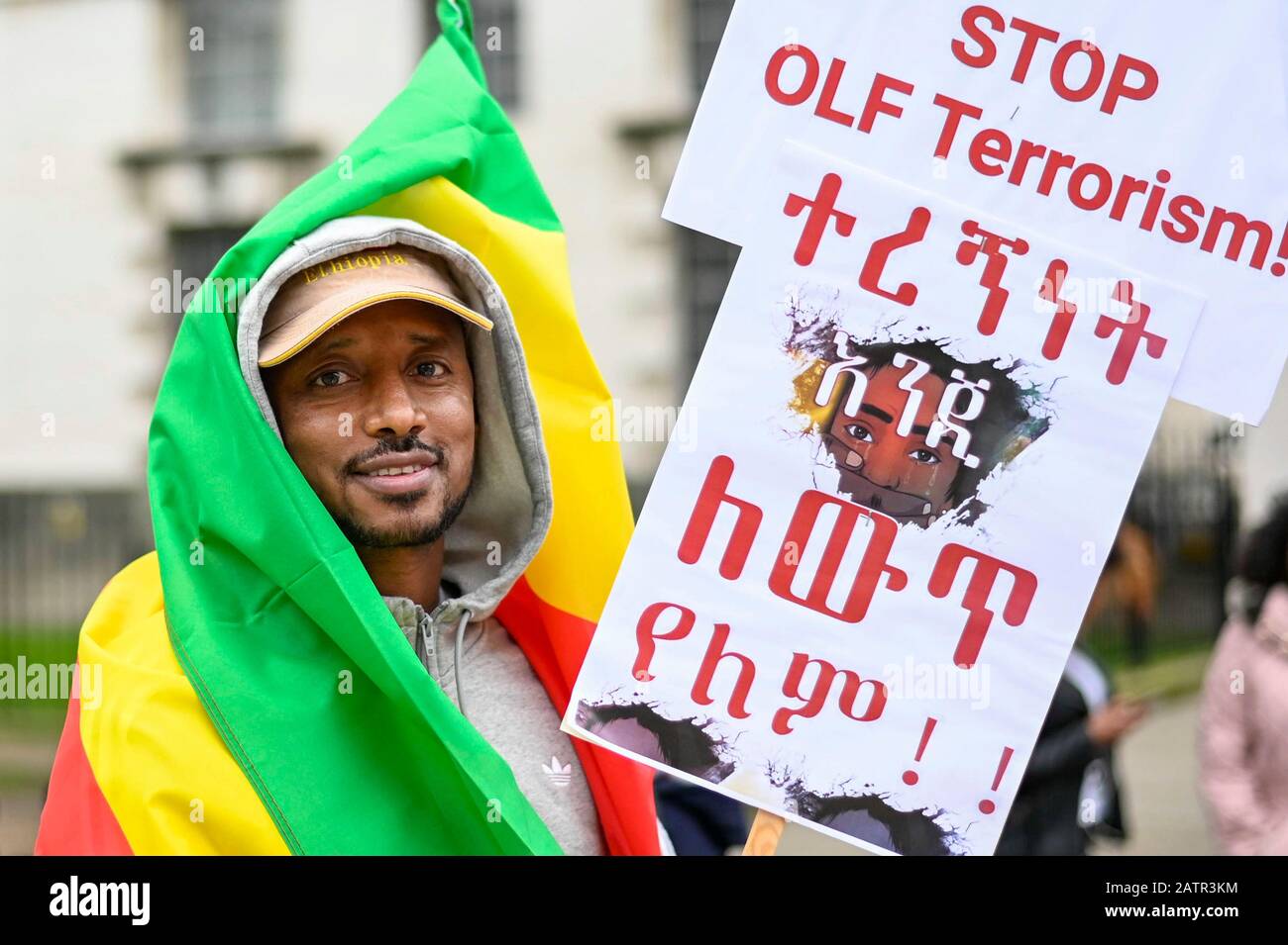 London, Großbritannien. Februar 2020. Ein Mann, der ein Schild trägt und in die panafrikanische Flagge gehüllt ist, nimmt an einem Protest außerhalb der Downing Street Teil, der Boris Johnson, Premierminister, auffordert, gegen die OLF (Oromo Liberation Front) in Äthiopien zu handeln. Kredit: Stephen Chung / Alamy Live News Stockfoto