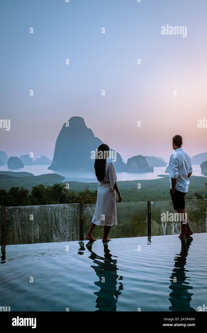 Aussichtspunkt Phanga Bay, ein Paar, das Sonnenaufgang am Rande eines Schwimmbads beobachtet, Infinity-Pool mit Blick auf Phangnga Bay Thailand Stockfoto