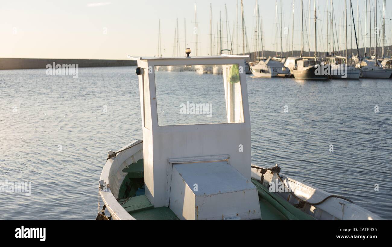 Das Fischerboot mit Wasseroberfläche wird vom Wasser geleult, während die Sonne am frühen Morgen vom Meer reflektiert wird Stockfoto