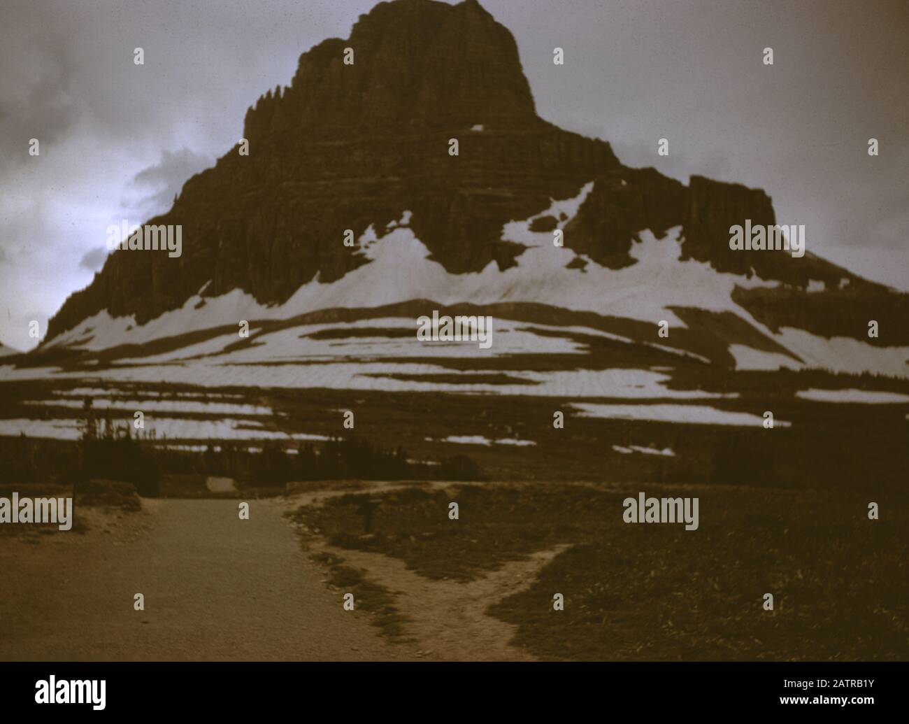 Nakuläres Foto, aufgenommen auf einer analogen 35-mm-Filmtransparenz, die vermutlich tagsüber schneebedeckte Berge abbildet. Zu den erkannten Grenzsteinen/Orten gehört der Glacier National Park. Zu den wichtigsten Themen/Objekten, die erfasst wurden, gehören Berglandformen, Berg, Himmel, Landschaft und Felsen. () Stockfoto