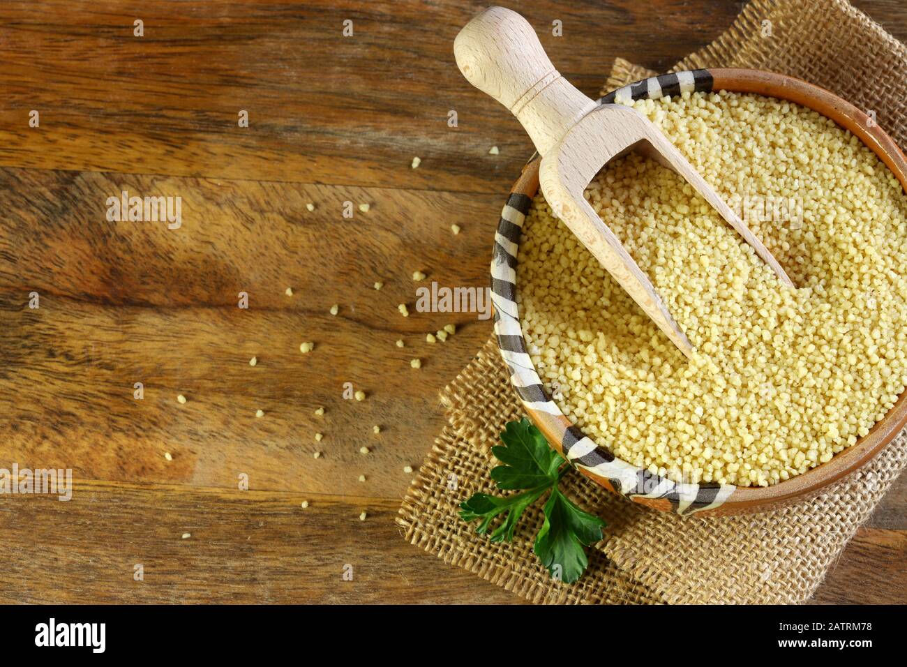 Nahaufnahme von Couscous in einer Schüssel auf Holztisch. Stockfoto