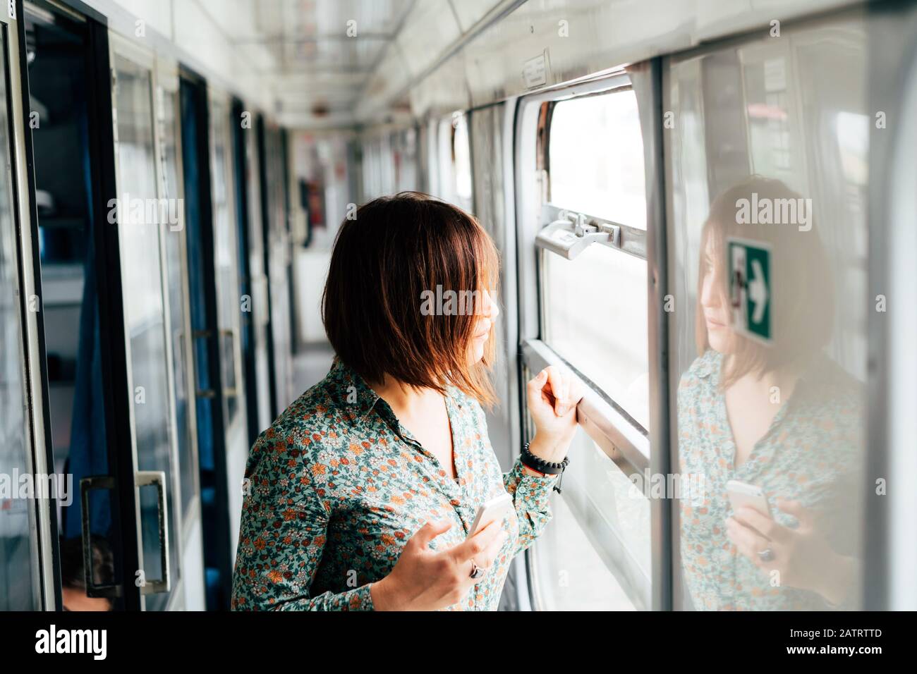 Attraktive dunkelhaarige Frau in ein Hemd mit einem Handy in der Hand. Stockfoto