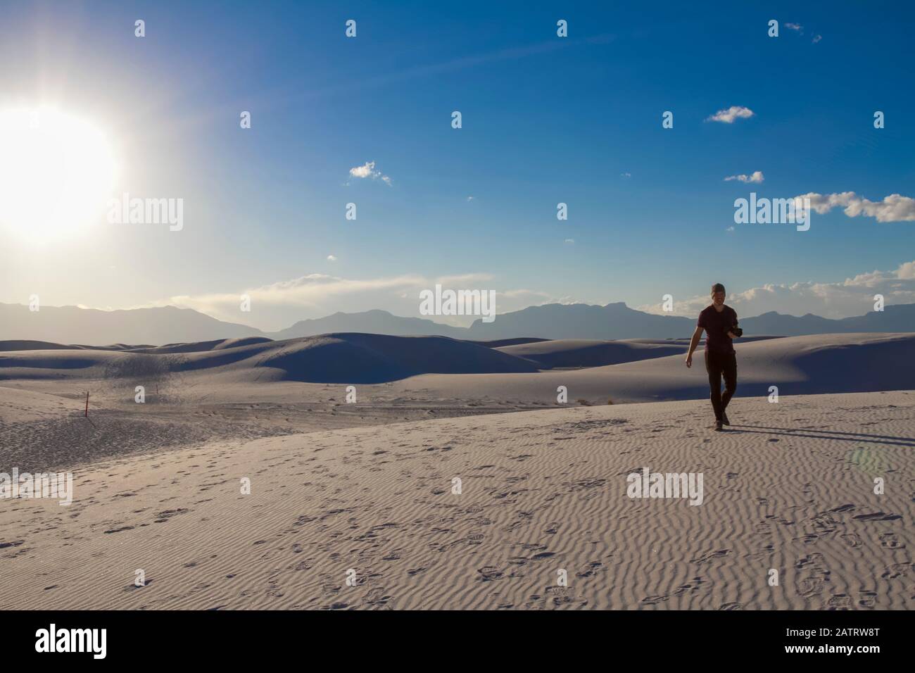 Männlicher Fotograf geht mit der Kamera auf den weißen Sand, White Sands National Monument; Alamogordo, New Mexico, Vereinigte Staaten von Amerika Stockfoto