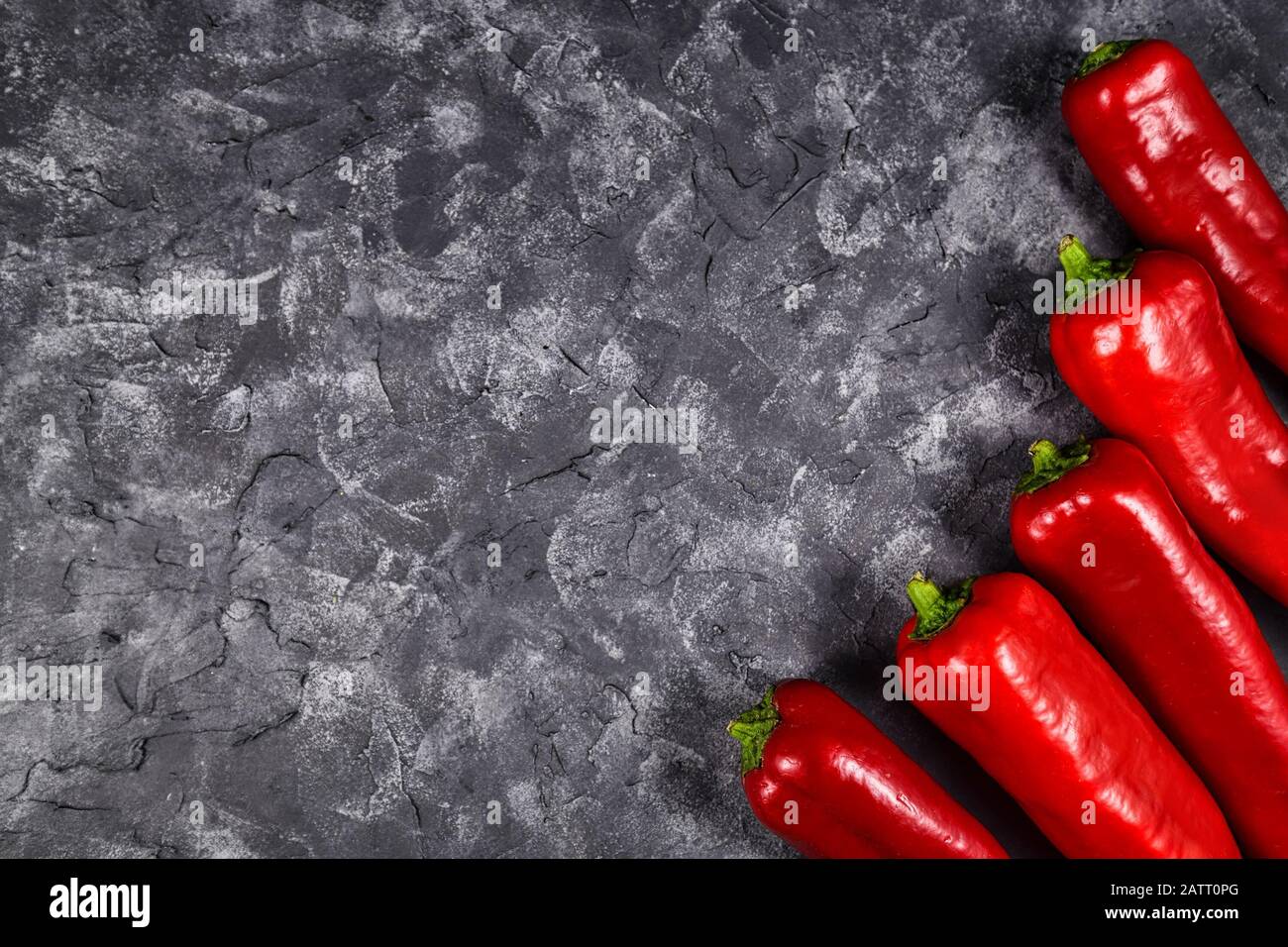 Chili-förmige rote Kapsicums Pfeffergemüse auf dunklem Hintergrund mit Kopierraum Stockfoto