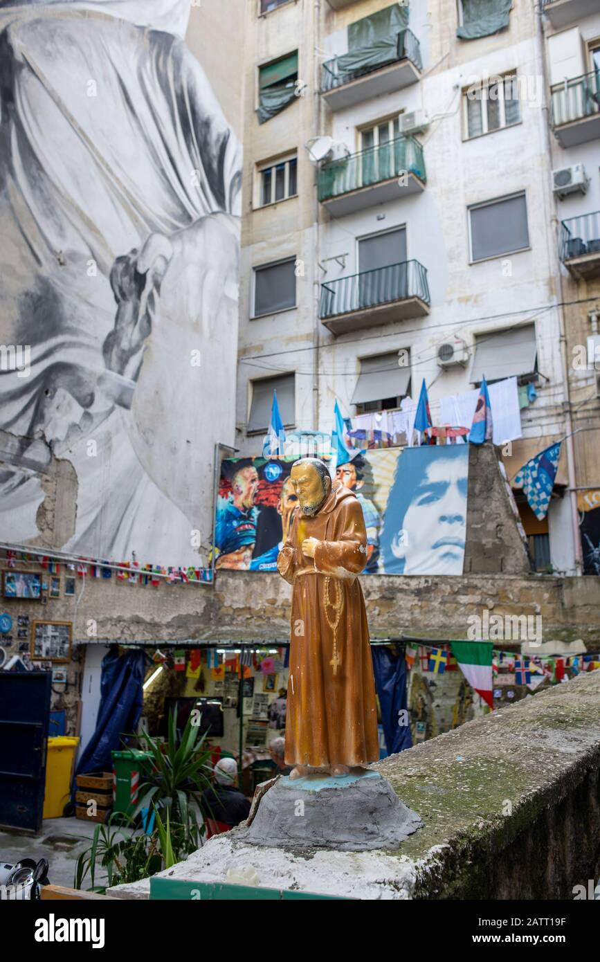 Die Statue eines Mönchs auf einer Mauer im Spanischen Viertel von Neapel, in der Nähe des Wandgemäldes von Diego Maradona Stockfoto