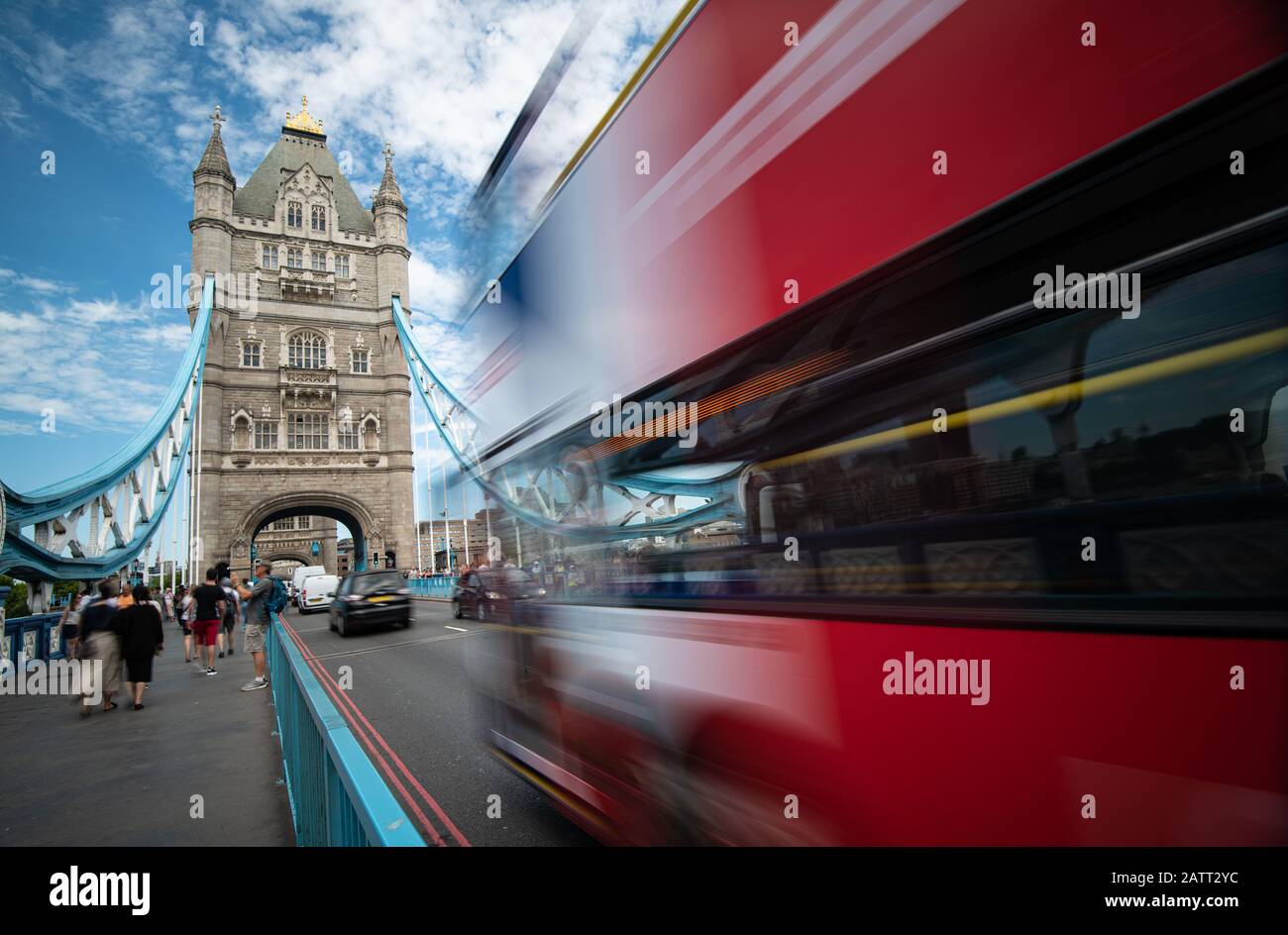 Menschen, die zu Fuß gehen und den roten, traditionellen Londoner Bus über die berühmte London Tower Bridge überqueren Stockfoto