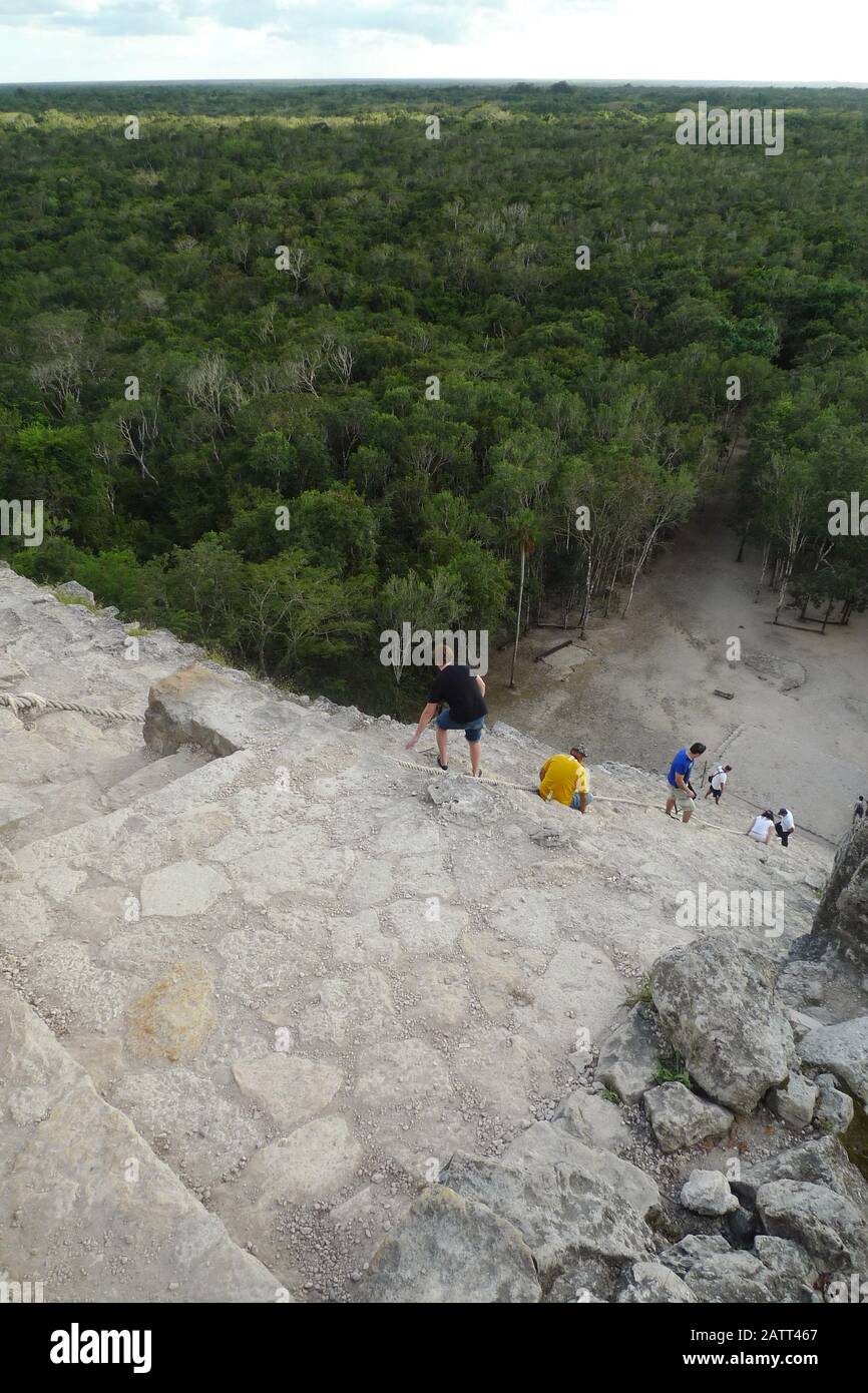 Die Menschen klettern auf die steilen Stufen der Nohoch Mul Pyramide bei den alten Maya-Ruinen in Coba, Quintana Roo, Mexiko. Stockfoto