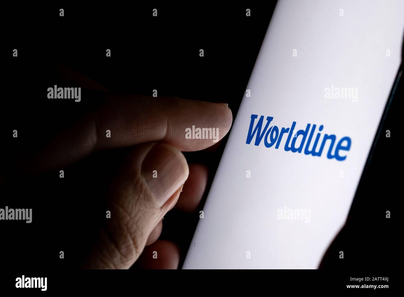 Logo der Firma Worldline Payment auf dem Bildschirm und Finger, um es zu berühren. Konzeptfoto. Stockfoto