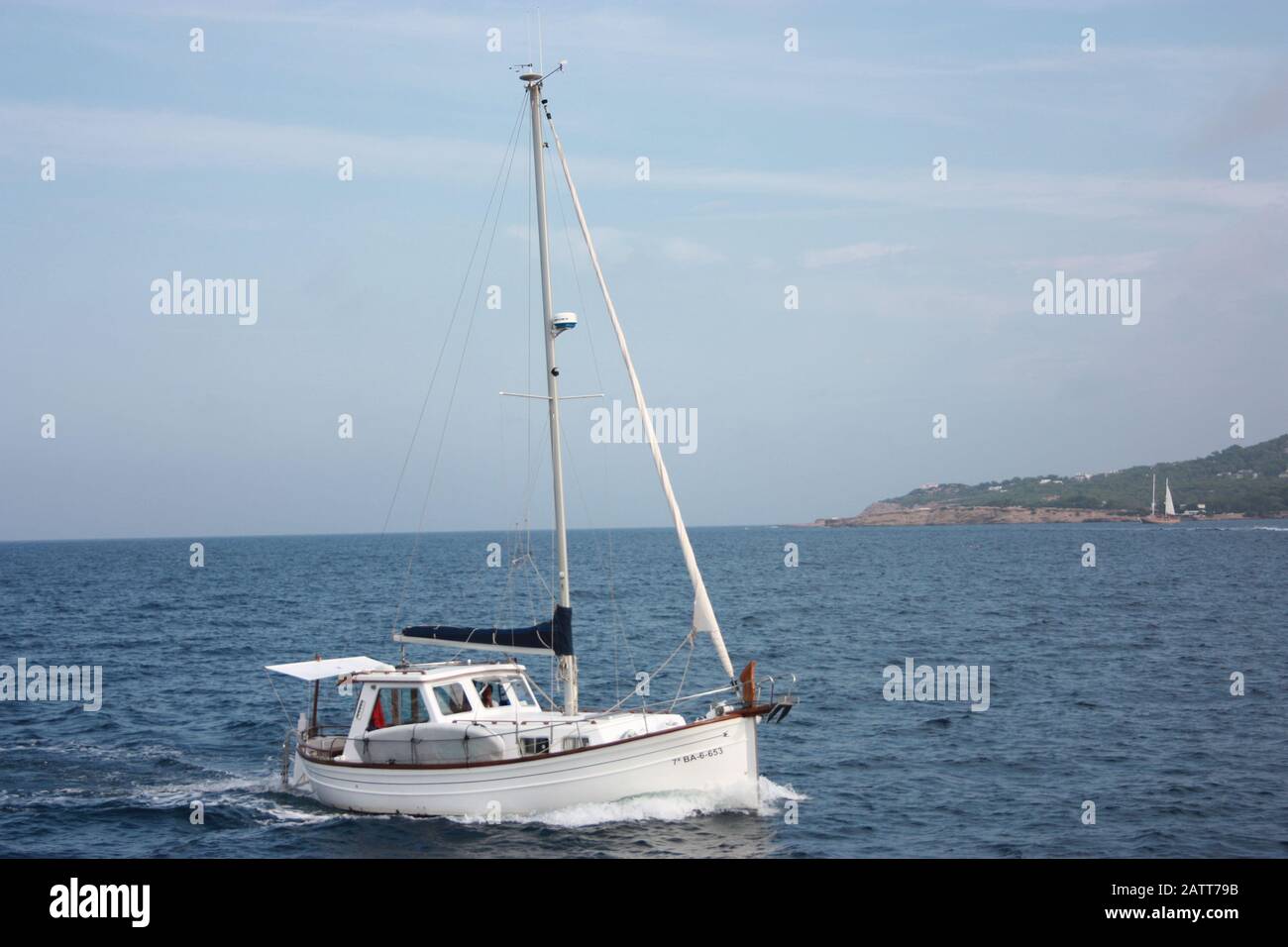 Ein weißes segelboot, das im Sommer blaues Wasser des Mittelmeeres in spanien einkochte Stockfoto