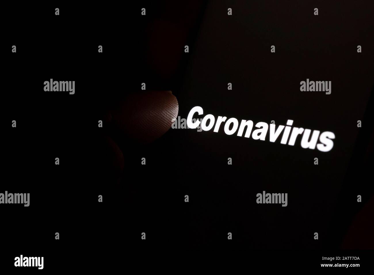 "Coronavirus"-Wort, das auf einem schwarzen Bildschirm leuchtet, und die Fingerspitze zeigt darauf. Konzept für Trauer und sein im Rampenlicht. Stockfoto