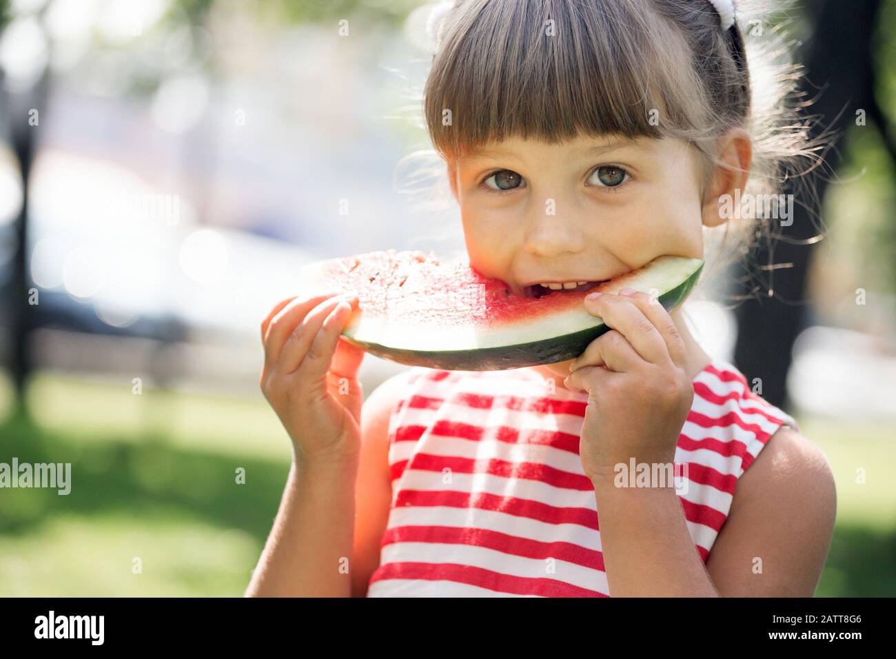 Happy Sommer - wunderschöne kleine Mädchen, Essen, Wassermelone auf dem grünen Rasen Stockfoto