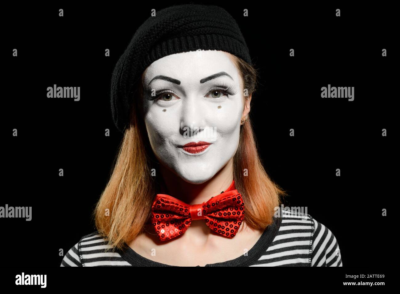 Süßer weiblicher MIME auf Schwarz. MIME-Schauspielerin, gekleidet mit gestreiftem T-Shirt Stockfoto