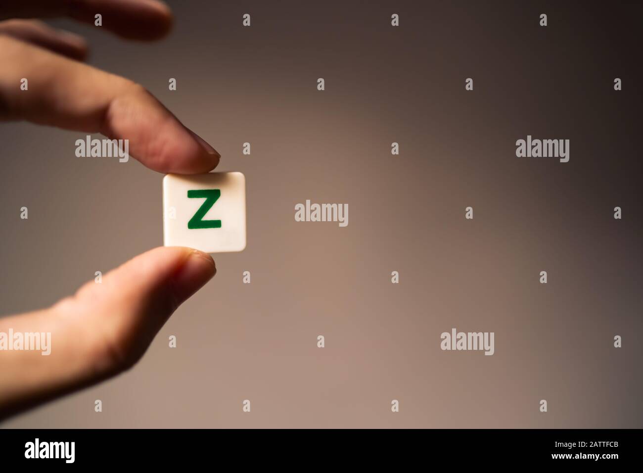 Z-Buchstabenkachel in der Hand mit Kopierraum. Konzept der Generation Z. Stockfoto