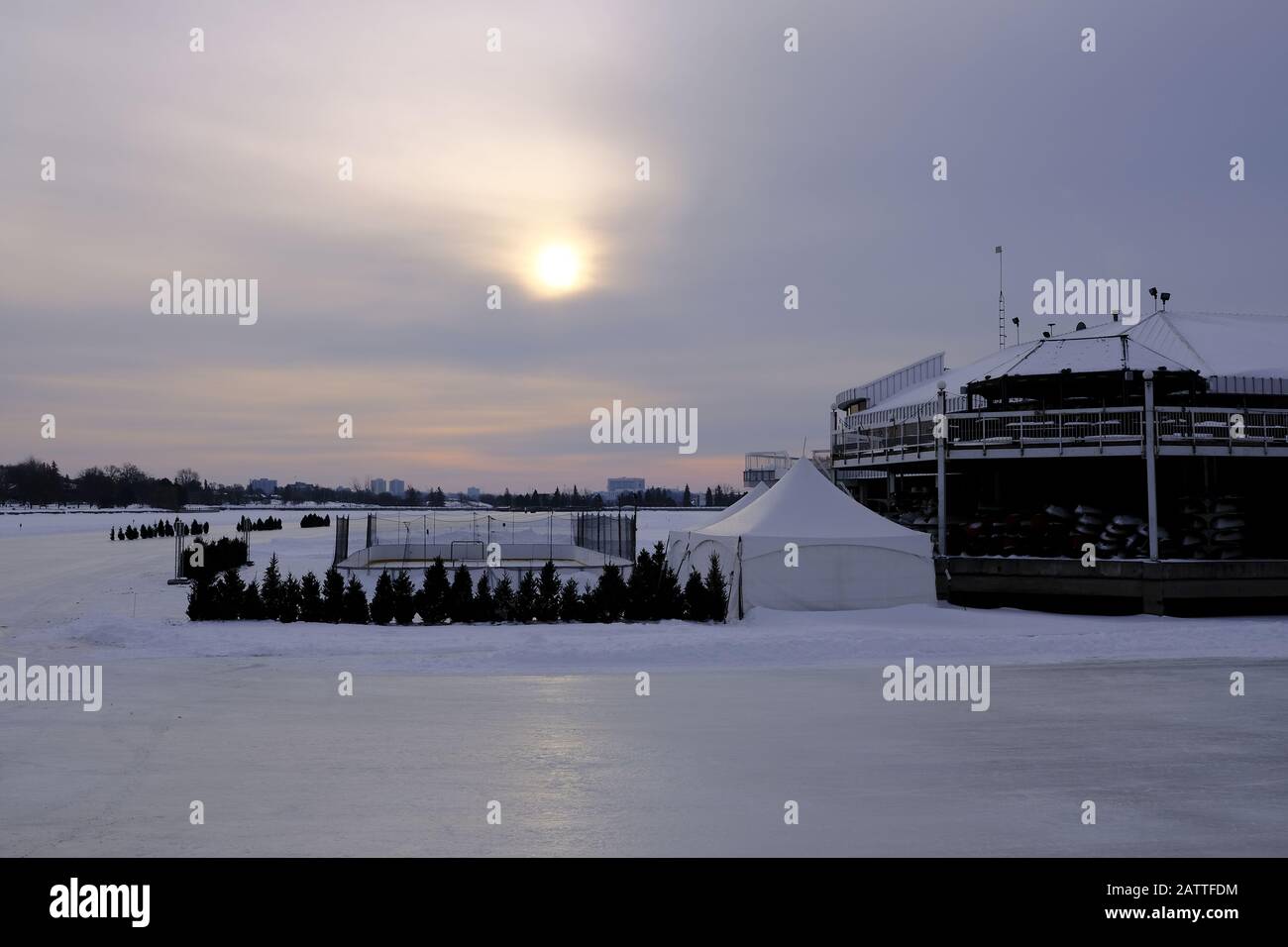 Sonne über einem sehr gefrorenen Dow's Lake and Pavilion und provisorischen Winterlude-Strukturen (einschließlich Eisbahn). Ottawa, Ontario, Kanada. Stockfoto