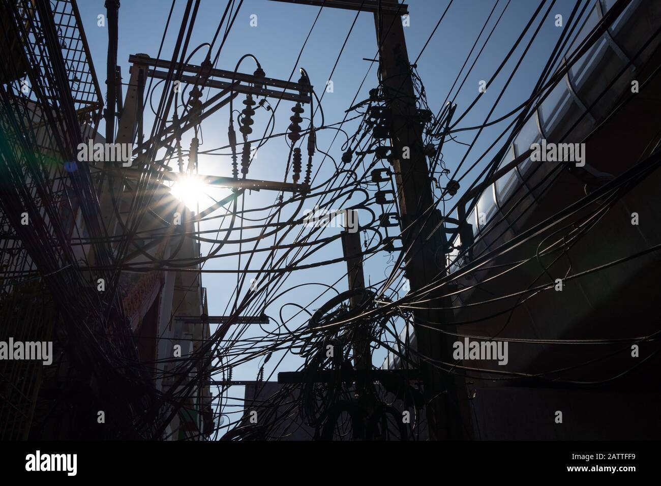 Silhouette von unordentlichen elektrischen Kabeln mit der Sonne Stockfoto