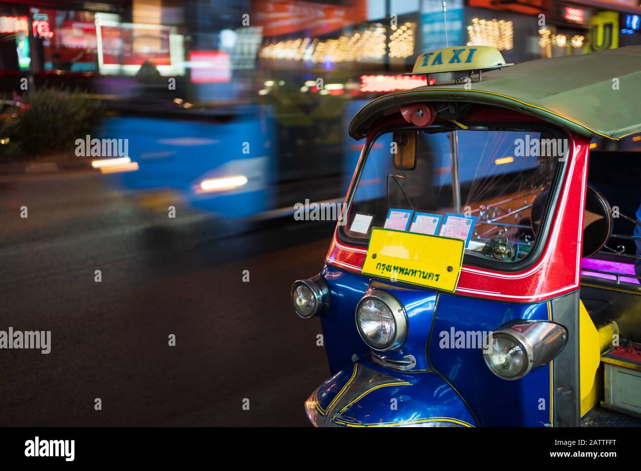 Tuk Tuk, ein Taxi mit 3 Rädern in Thailand, ist nachts in Bangkok unterwegs. Ein Wort auf dem Nummernschild ist ein thailändisches Wort „Krungthepmahanakhon“, das Bangkok bedeutet. Stockfoto