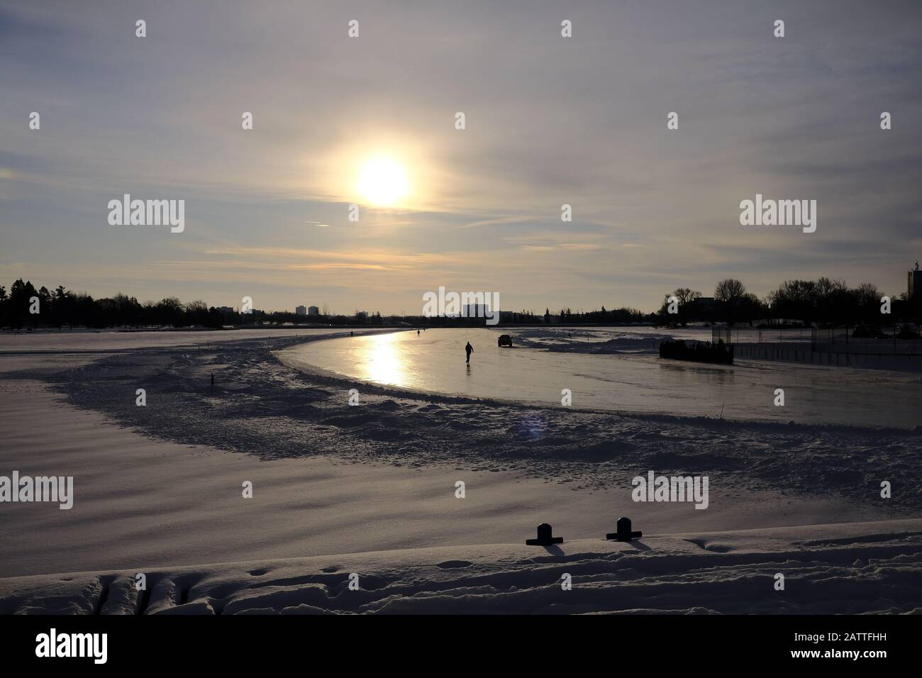 Skater am frühen Morgen unter einem blassen, winterlichen Sonnenlauf auf dem Rideau Canal Skgateway, Ottawa, Ontario, Kanada. Stockfoto