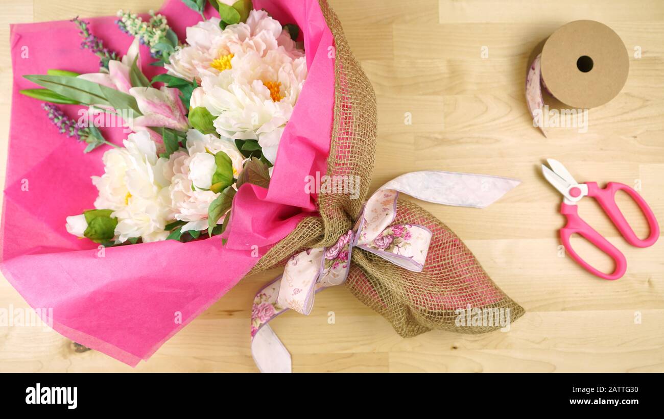 Blumen in rosa Gewebe und Hessischen moderne Verpackung flach verpackt für Muttertag, Geburtstag oder Valentinstag feiern. Stockfoto