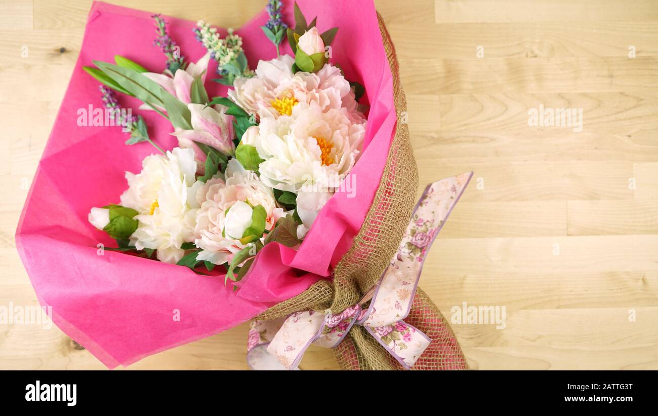 Blumen in rosafarbenem Gewebe und hessisches modernes Trend-Wrapping flach lagen für Muttertag, Geburtstag oder Valentinstag Feiern. Negative Kopie sp Stockfoto