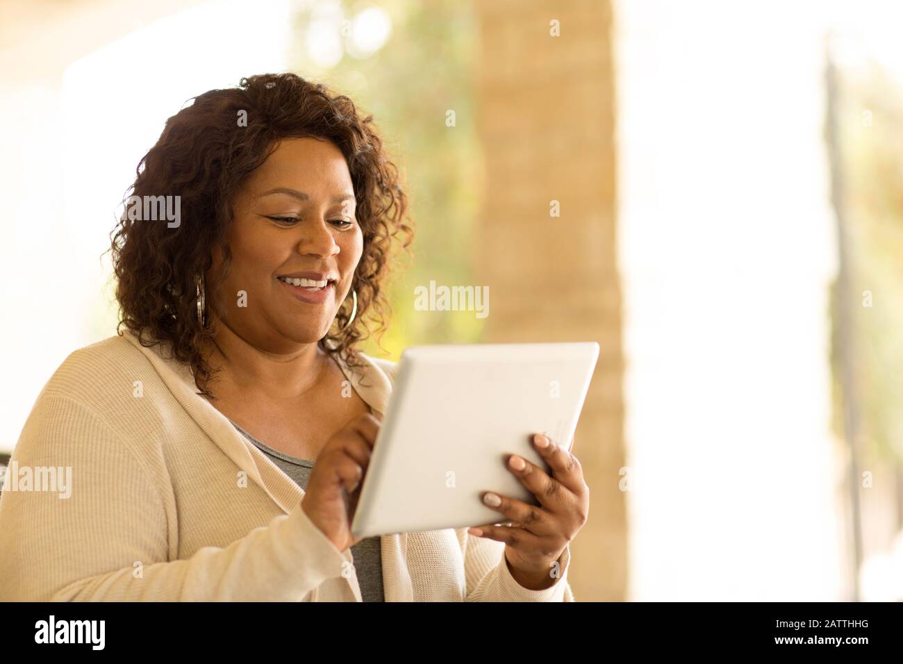 Lächelnd afrikanische amerikanische Frau an einer Tablette. Stockfoto