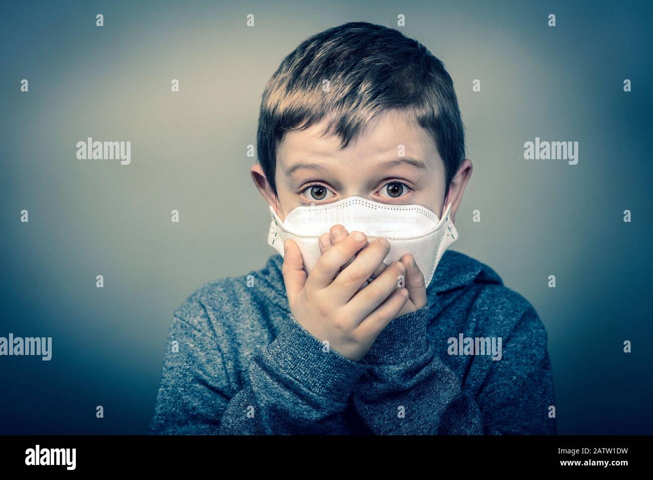 Kind mit Gesichtsmaske umhüllt seine Hände über den Mund. Virenschutzkonzept. Corona-Virus. Medizinische Prävention und Gesundheit. Stockfoto