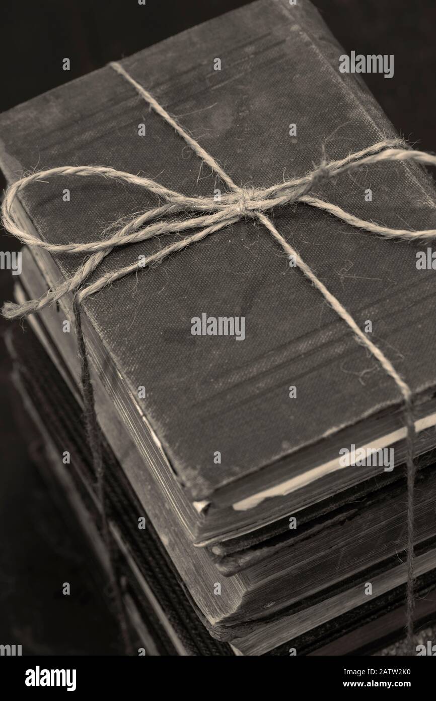 Antike alte Bücher, die in einen Haufen gestapelt sind, der mit einer Schnur verbunden ist. Mit Farbtonierung Stockfoto