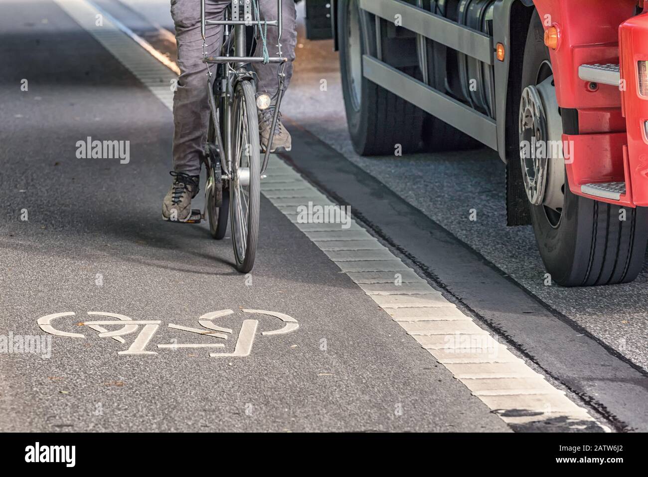 Fahrradfahren auf der Fahrspur neben einem Lastwagen Stockfoto