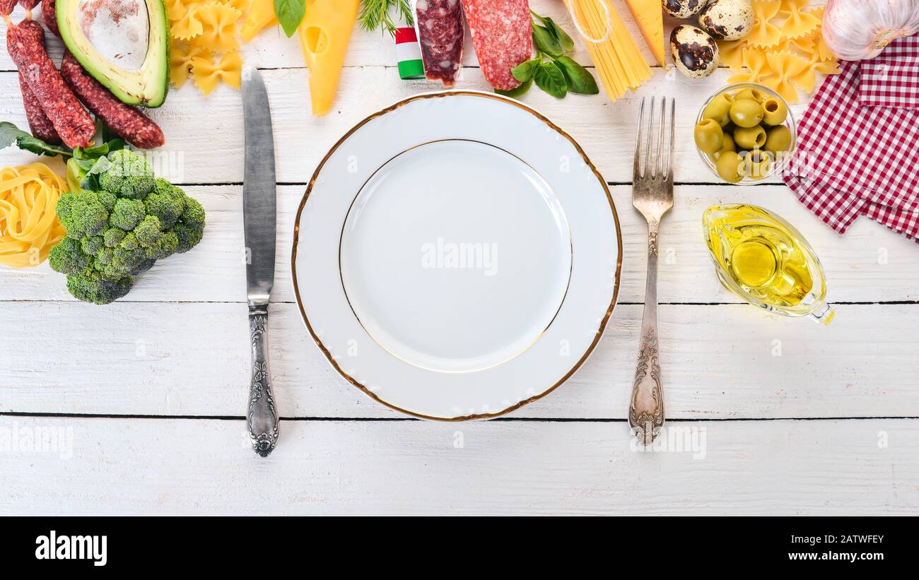Italienische Wurst, Käse und Gemüse. Auf weißem Holzhintergrund. Draufsicht. Kopierbereich. Stockfoto