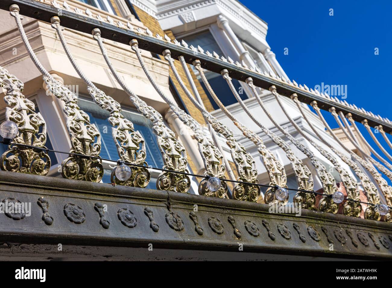 Attraktive Parade von Geschäften an der Monson Road, Tunbridge Wells, mit Wohnungen oben mit Balkon und dekorativer Schmiedeeiserner Balustrade, Kent, Großbritannien Stockfoto