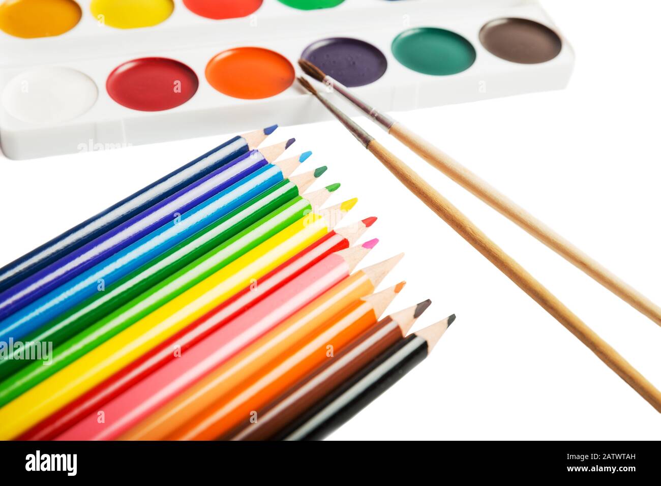 Farbstifte, ein Satz von Aquarellfarben und Pinsel werden auf weißem Hintergrund isoliert Stockfoto