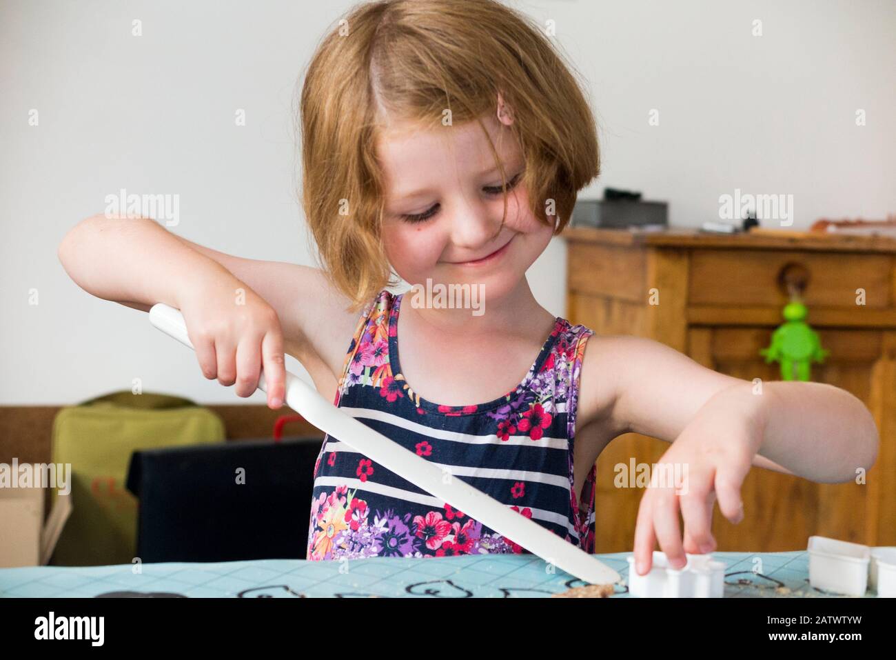 Mädchen im Alter von 5 / 5 Jahren, die ein Gebäckschneider beim Backen von Keksrezepten aus Zutaten/Keksen verwenden; Hauskochbacken mit Kindern/Kindern. (112) Stockfoto