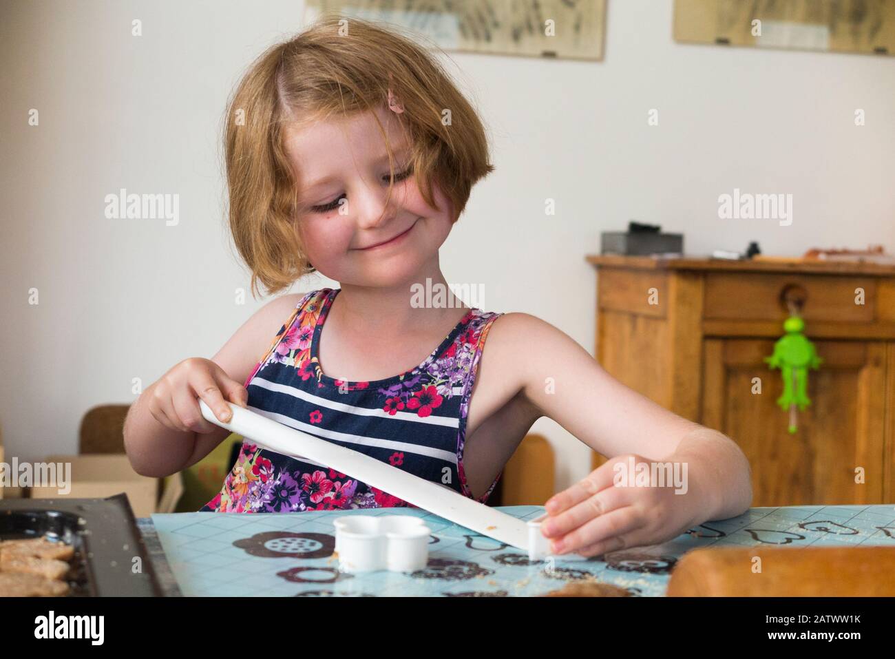 Mädchen im Alter von 5 / 5 Jahren, die ein Gebäckschneider beim Backen von Keksrezepten aus Zutaten/Keksen verwenden; Hauskochbacken mit Kindern/Kindern. (112) Stockfoto