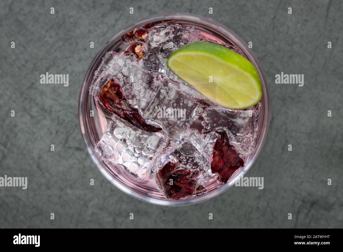 Pink Gin Tonic Wodka Soda Fruit Grapefruit Cocktailgetränk in Glas mit Eis, Draufsicht auf dunklem Hintergrund Stockfoto