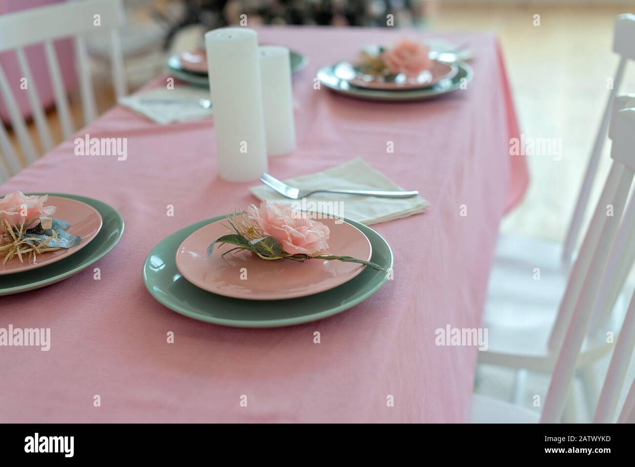 Festlicher Tisch mit Kerze und pinkfarbenem Tischtuch. Die Feier der Veranstaltung Stockfoto